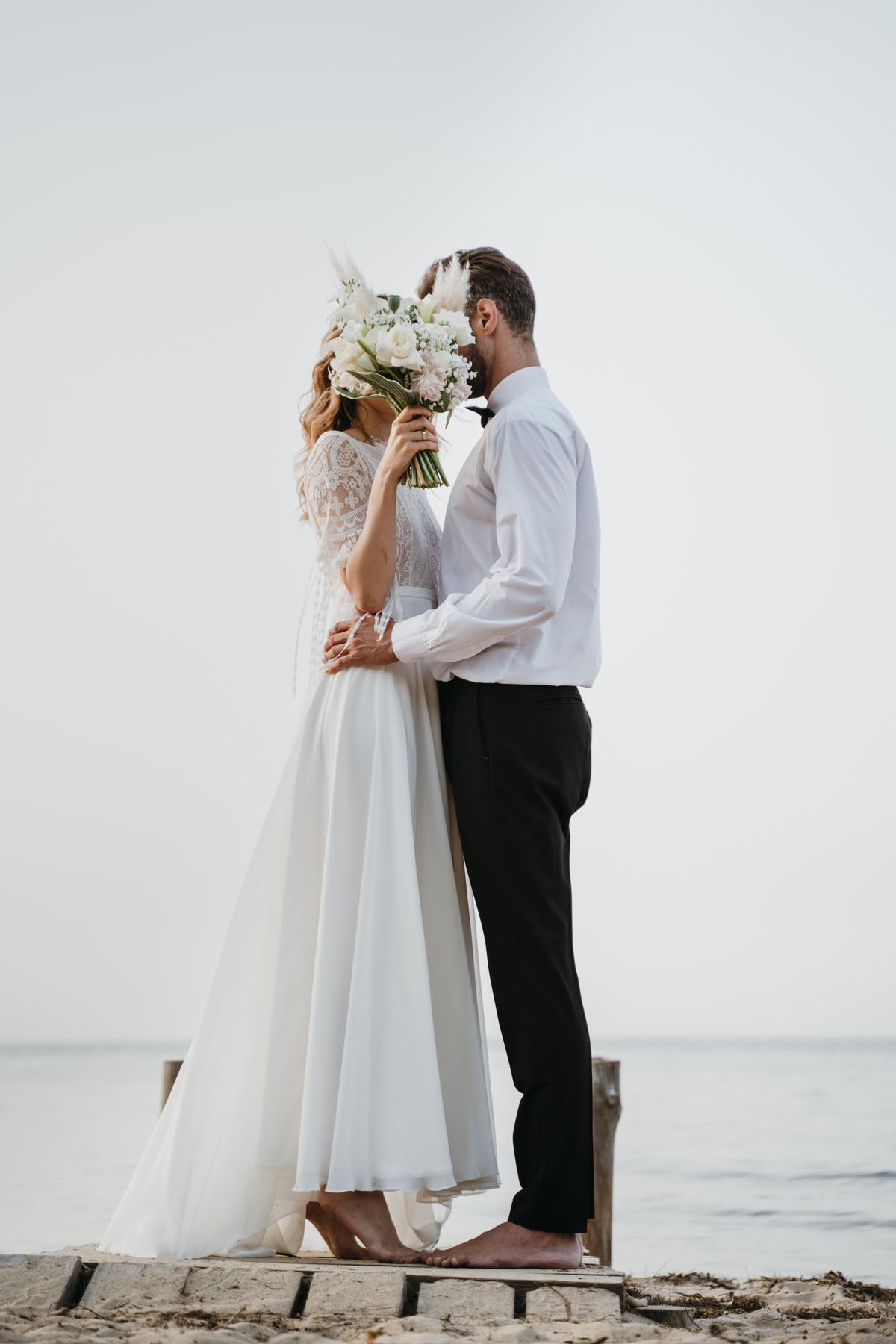 Casal de noivos celebrando o casamento na praia